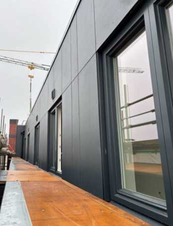 Commercial glazing installation with aluminium-framed windows and doors on a modern building during final project inspection.